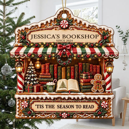 Gingerbread bookstore facade ornament with striped awning, wreath, books, lanterns, and 'TIS THE SEASON TO READ' text.