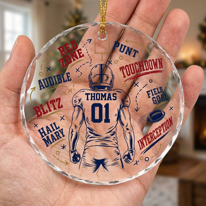 Round faceted glass ornament with football player back view, goalpost, football, and play diagrams in navy, dark red, an
