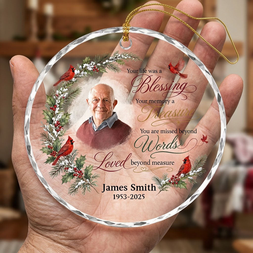 Round glass ornament with memorial quote, four red cardinals, pine and holly greenery, and a center photo portrait.