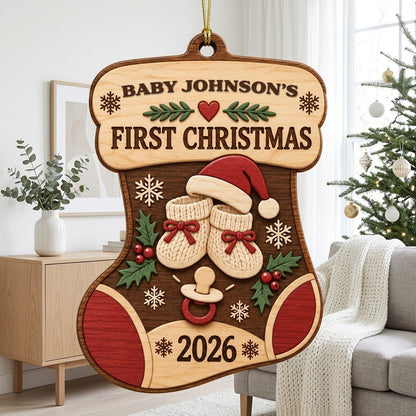 Stocking-shaped wood ornament with baby booties, Santa hat, holly, snowflakes, and FIRST CHRISTMAS text.