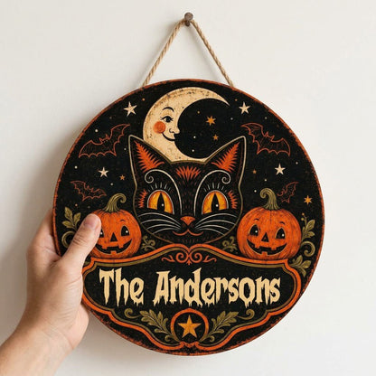Round wooden sign with vintage black cat face, crescent moon, pumpkins, bats, stars and custom family name.