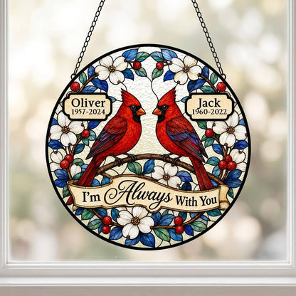 Round suncatcher with two red cardinals on a branch, dogwood flowers, a scroll banner and two name plaques.
