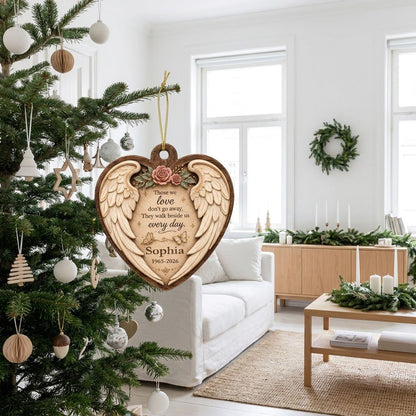Heart-shaped wood ornament with angel wings, pink roses, butterflies, and a memorial quote with name and dates.