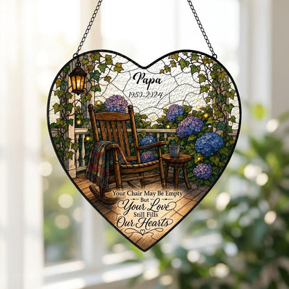Heart stained glass suncatcher with empty porch rocking chair, lantern, ivy, and purple and blue hydrangea bushes.