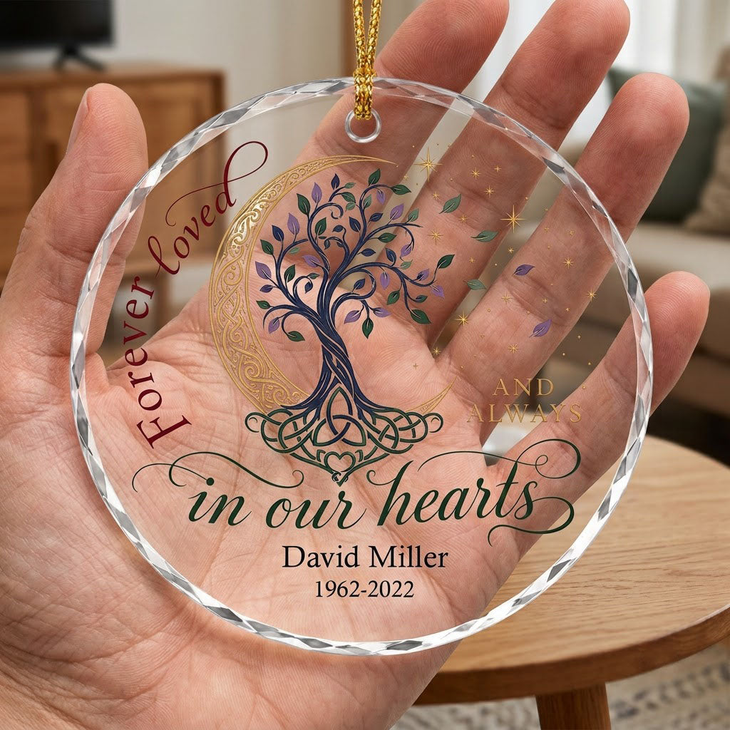 Round glass ornament with Celtic tree of life, gold crescent moon, stars, and phrase Forever loved in our hearts.
