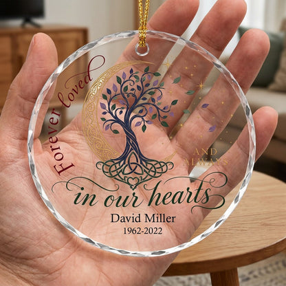 Round glass ornament with Celtic tree of life, gold crescent moon, stars, and phrase Forever loved in our hearts.