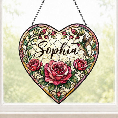 Heart stained-glass suncatcher with pink and red roses, a right-side hummingbird, and a multi-colored border.