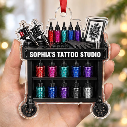 Acrylic ornament shaped like a tattoo cart with machines, colorful inks, and 'SOPHIA'S TATTOO STUDIO' text.