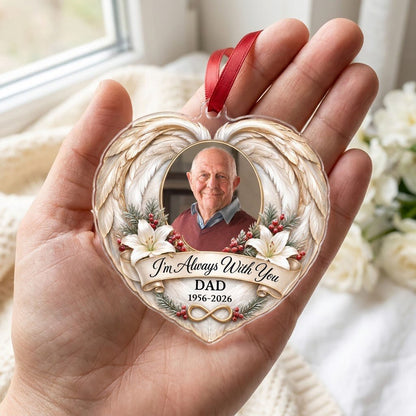 Heart-shaped acrylic ornament with angel wings, oval photo frame, white lilies, pine sprigs, red berries, and 'I'm Alway