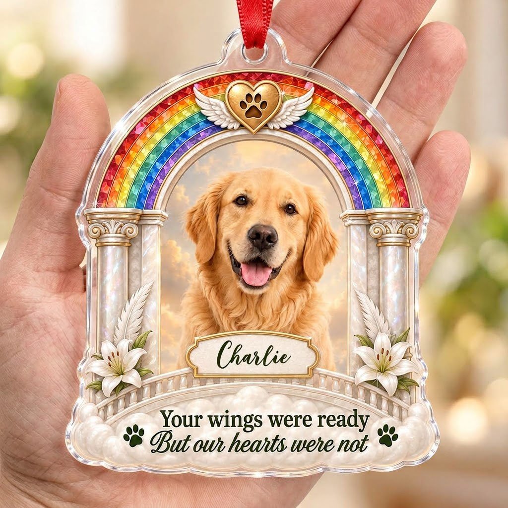 A rainbow arch pet memorial acrylic ornament with a winged golden heart, paw print, lilies, pillars, clouds and a photo 