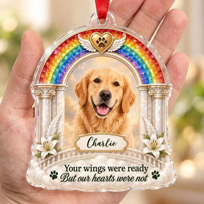 A rainbow arch pet memorial acrylic ornament with a winged golden heart, paw print, lilies, pillars, clouds and a photo 