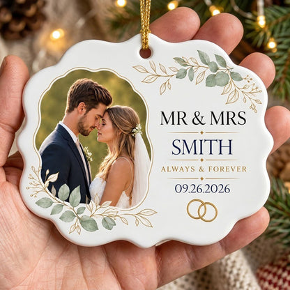 White scalloped ceramic medallion with MR & MRS, eucalyptus, gold rings, and a couple’s photo on the left.