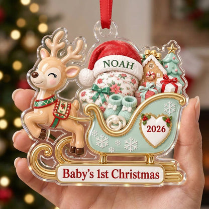Acrylic ornament of a reindeer pulling a mint-green sleigh with a baby, gifts, and 'Baby's 1st Christmas' text.