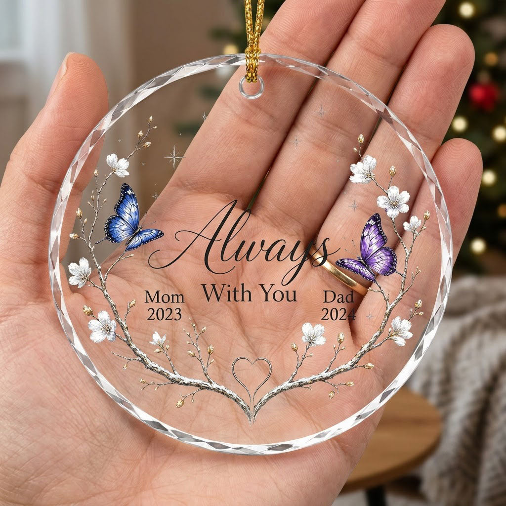 Round glass ornament with branch wreath, white blossoms, blue and purple butterflies, and Always With You text.