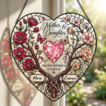 Heart-shaped stained-glass style suncatcher with intertwined trees, red and pink flowers, butterflies, and a pink gem he