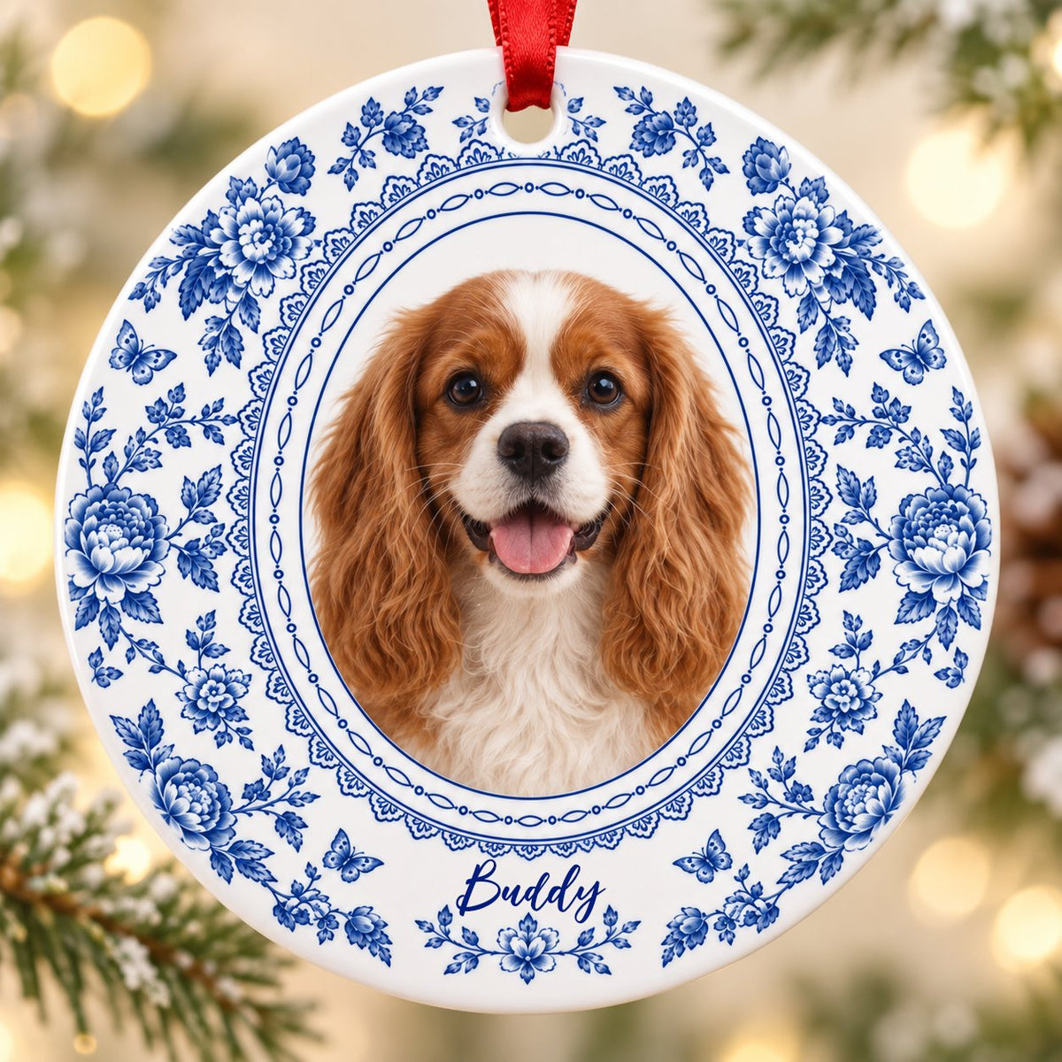 Round white ceramic ornament with blue Delft floral and butterfly pattern around an oval dog photo and name.