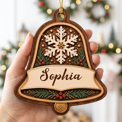 Personalized wooden bell ornament with snowflake, pine sprigs, red berries, and a name on the center banner.