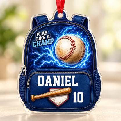 Backpack-shaped acrylic ornament with a baseball, blue lightning, a bat on home plate, and PLAY LIKE A CHAMP text.