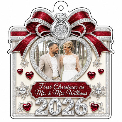 Acrylic ornament with red glitter bow, engagement ring, heart photo frame, snowflakes, and Mr. & Mrs. name and year.