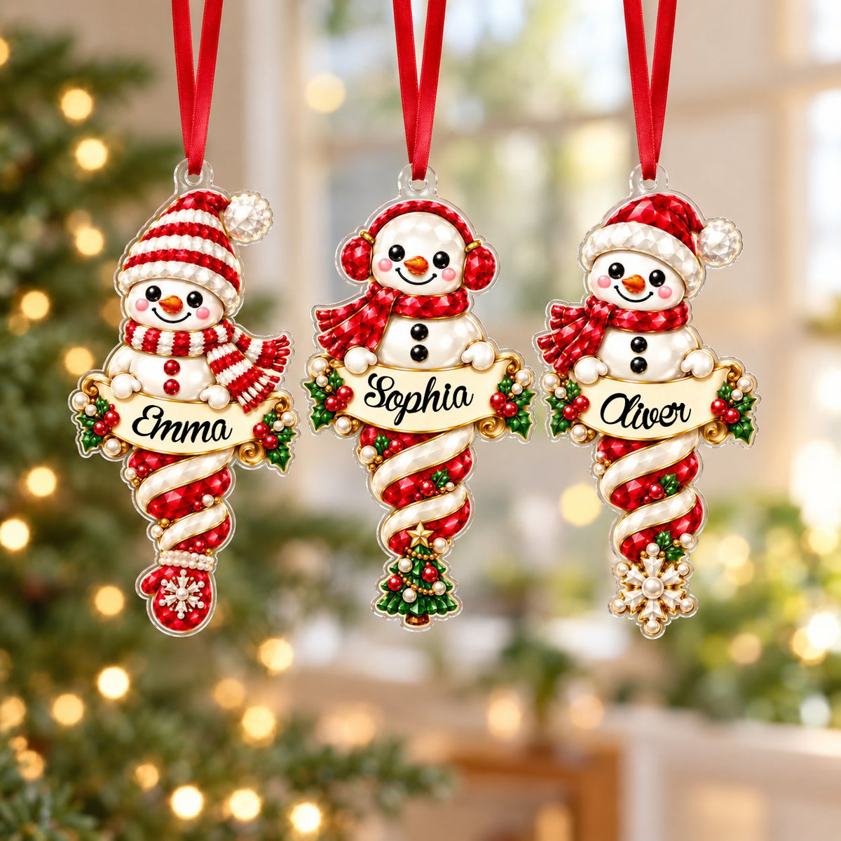Custom-cut acrylic snowman ornaments with red scarves and scroll banners personalized with a child's name.