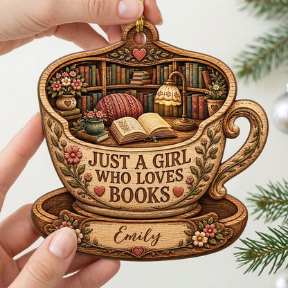 Teacup-shaped wood ornament with cozy library scene and 'JUST A GIRL WHO LOVES BOOKS' plus a personalized name.