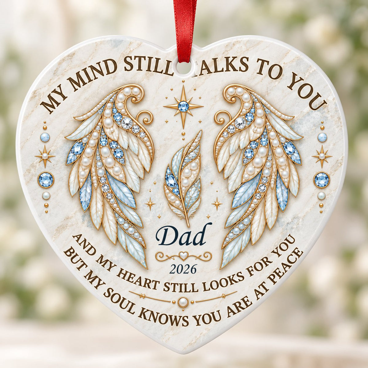 White heart ceramic ornament with jeweled angel wings, blue gems, gold scrollwork, personalized name and year.