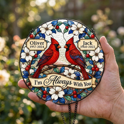 Round suncatcher with two red cardinals on a branch, dogwood flowers, a scroll banner and two name plaques.