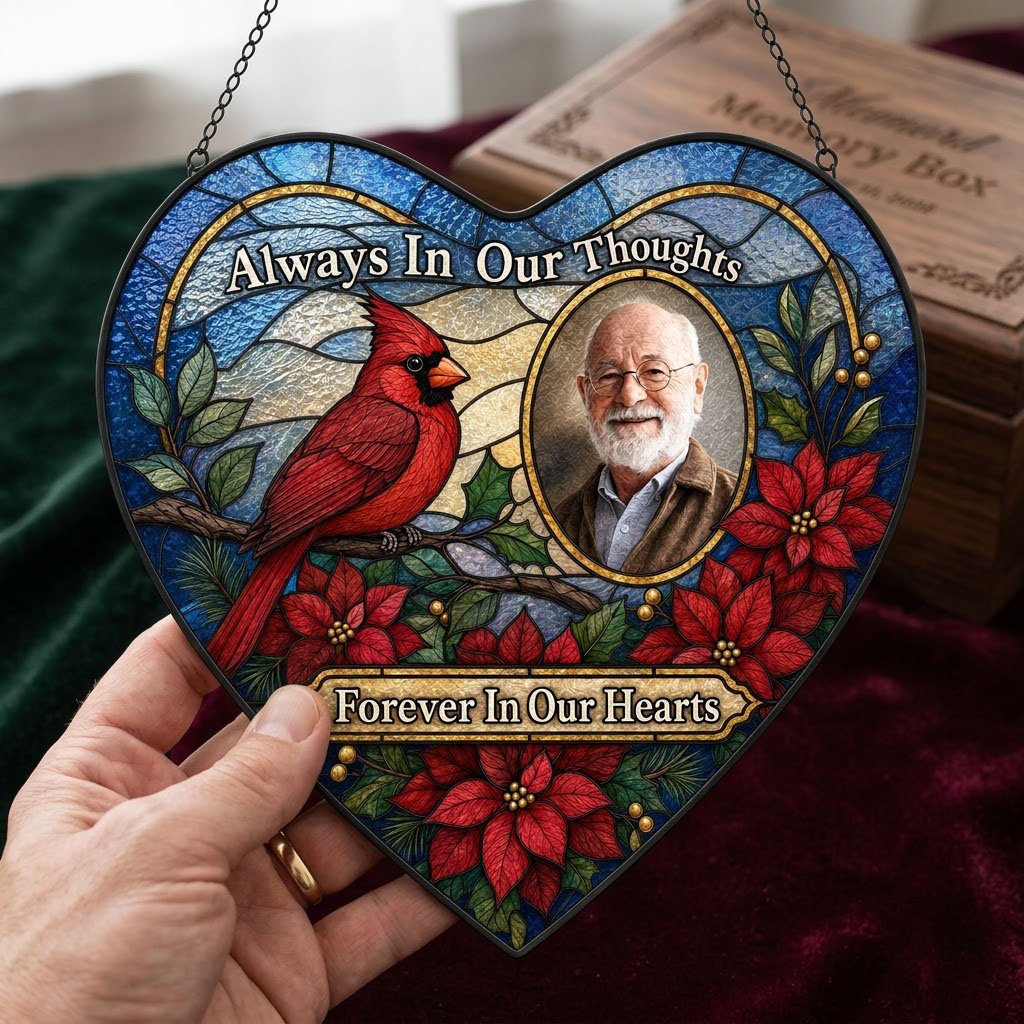 Heart stained glass suncatcher with red cardinal, oval memorial photo frame, and red poinsettias with green leaves.