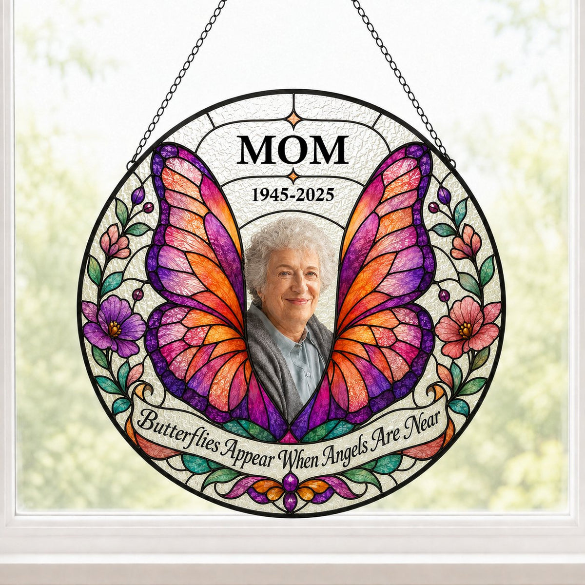 Round stained-glass suncatcher with butterfly wings, purple and pink flowers, a photo arch and a name banner.