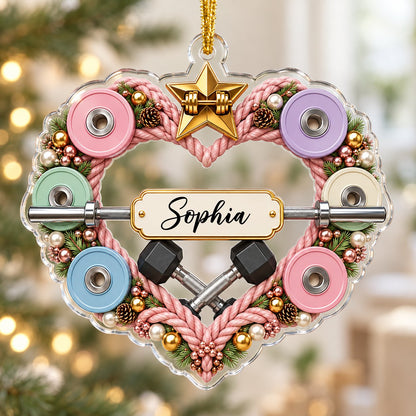Clear acrylic heart ornament with pink rope wreath, pastel plates, barbell, crossed dumbbells, and a name plaque.