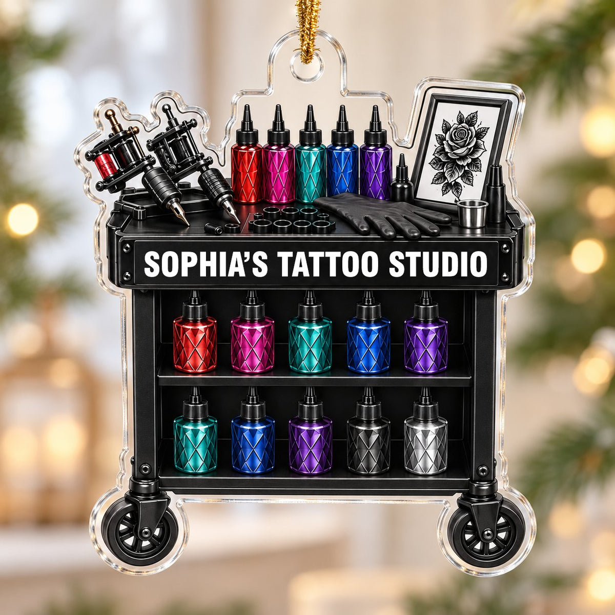 Acrylic ornament shaped like a tattoo cart with machines, colorful inks, and 'SOPHIA'S TATTOO STUDIO' text.