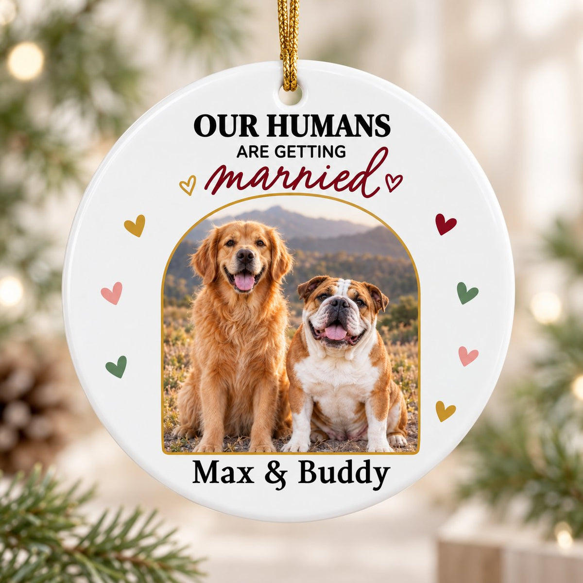 Round ceramic ornament with arch dog photo, “OUR HUMANS ARE GETTING married” text, and colorful heart accents.