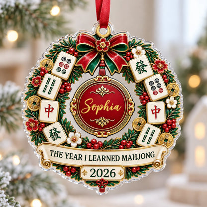 A clear acrylic wreath ornament with Mahjong tiles, red bow, gold coins, and the text THE YEAR I LEARNED MAHJONG.