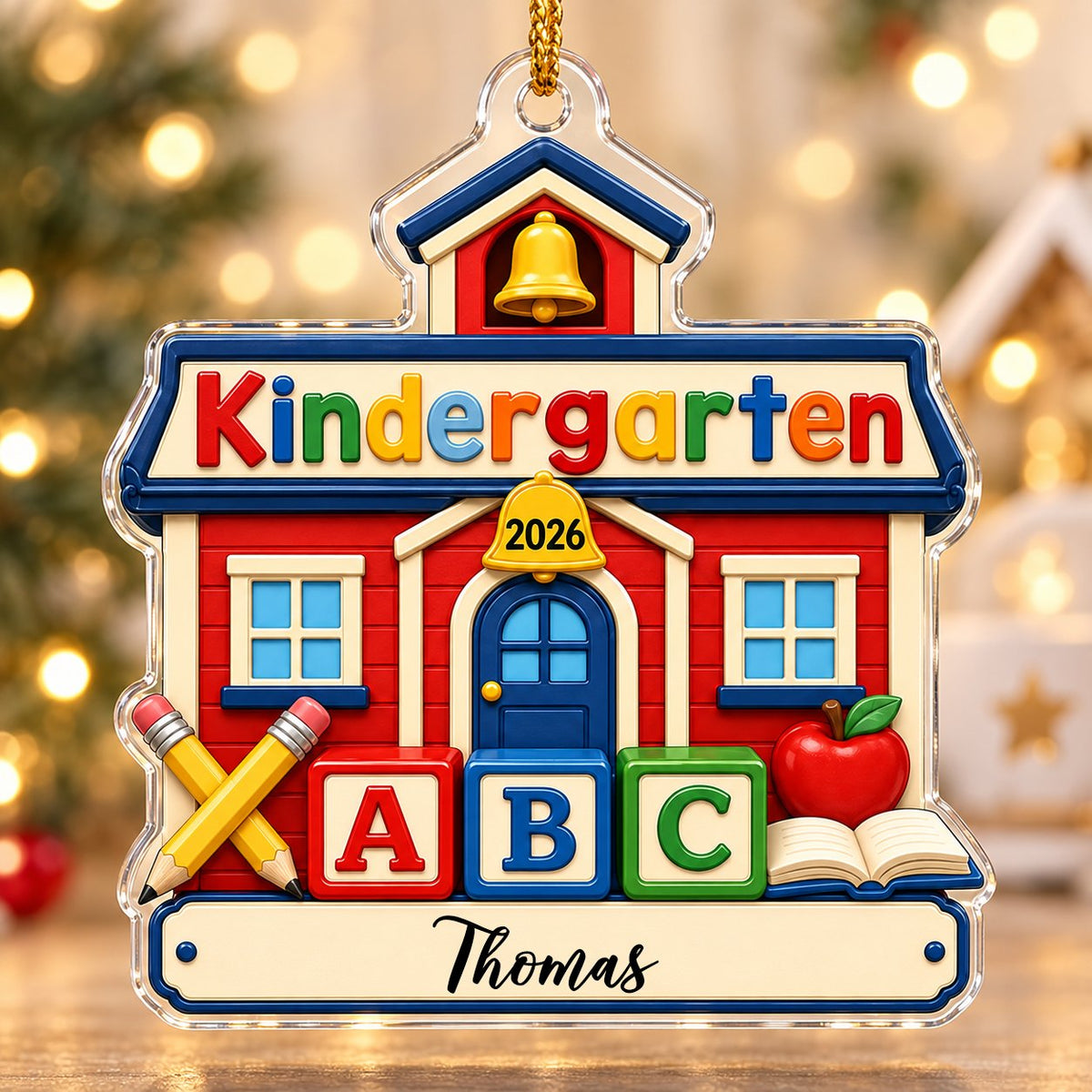 Red schoolhouse acrylic ornament with Kindergarten 2026, ABC blocks, pencils, apple, and a name on a white banner.