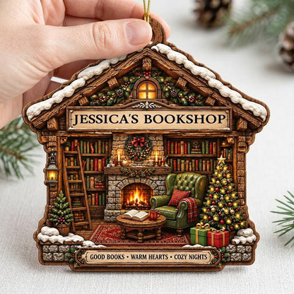 House-shaped wood ornament with cozy bookshop scene, fireplace, bookshelves, and a lit Christmas tree.