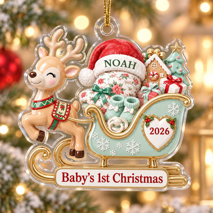 Acrylic ornament of a reindeer pulling a mint-green sleigh with a baby, gifts, and 'Baby's 1st Christmas' text.