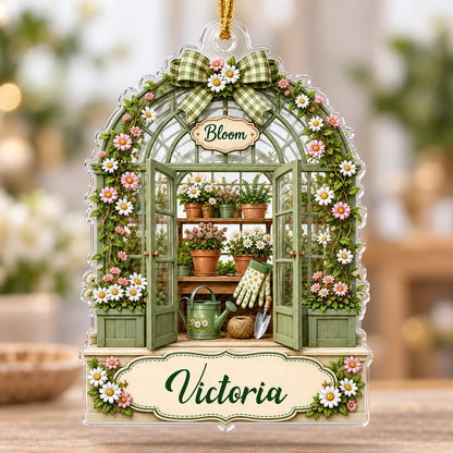 Arched acrylic ornament of a green greenhouse with daisy bow, flowers, tools, and 'Bloom' with a personalized name.