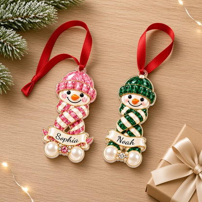 Custom-cut acrylic snowman ornament with jeweled hat and scarf, name banner, and faux pearl base.