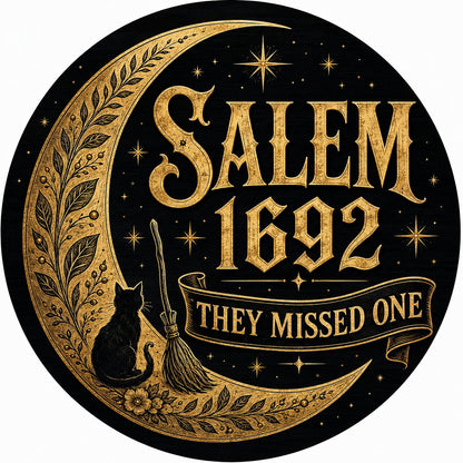 Round wooden sign with gold crescent moon, black cat, broomstick, stars and 'SALEM 1692 THEY MISSED ONE' on black.