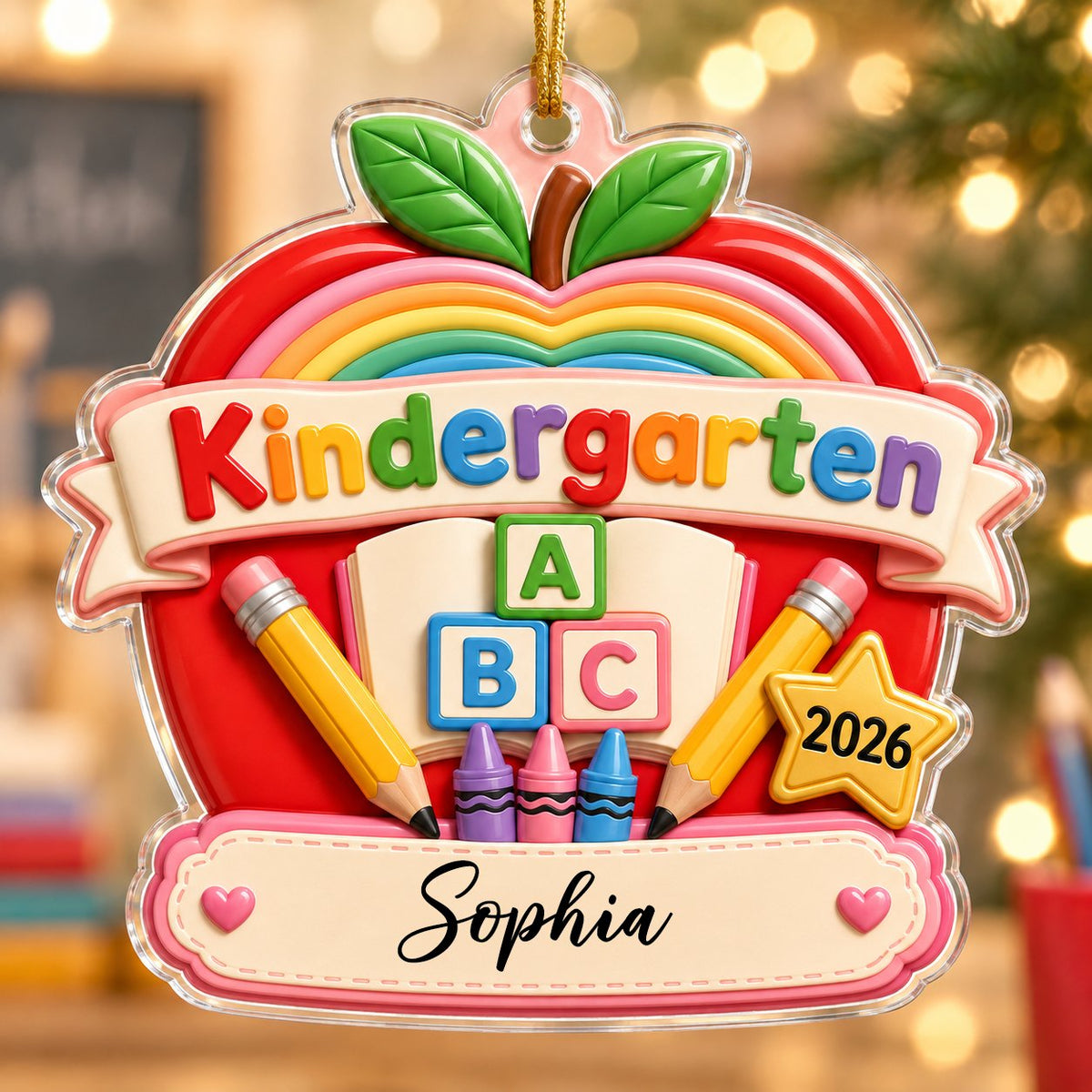 Red apple acrylic ornament with 'Kindergarten 2026', rainbow, ABC blocks, crayons, pencils, star badge, and a name banne