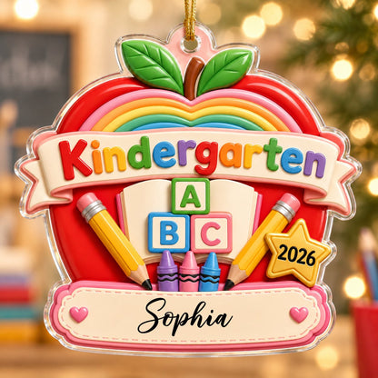 Red apple acrylic ornament with 'Kindergarten 2026', rainbow, ABC blocks, crayons, pencils, star badge, and a name banne
