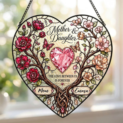 Heart-shaped stained-glass style suncatcher with intertwined trees, red and pink flowers, butterflies, and a pink gem he