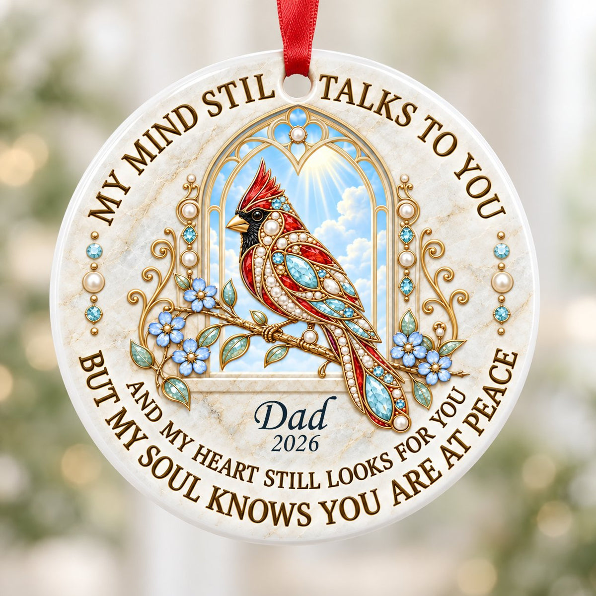 Round ceramic ornament with a red cardinal by a gold arched window, blue flowers, pearls, and a faux marble border.