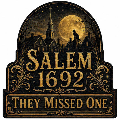 Custom-cut wooden sign reading “SALEM 1692” and “THEY MISSED ONE” with a black cat on a moonlit village and gold filigre