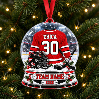 Snow globe acrylic ornament with red and white hockey jersey, black helmet and puck, and a snowy rink backdrop.