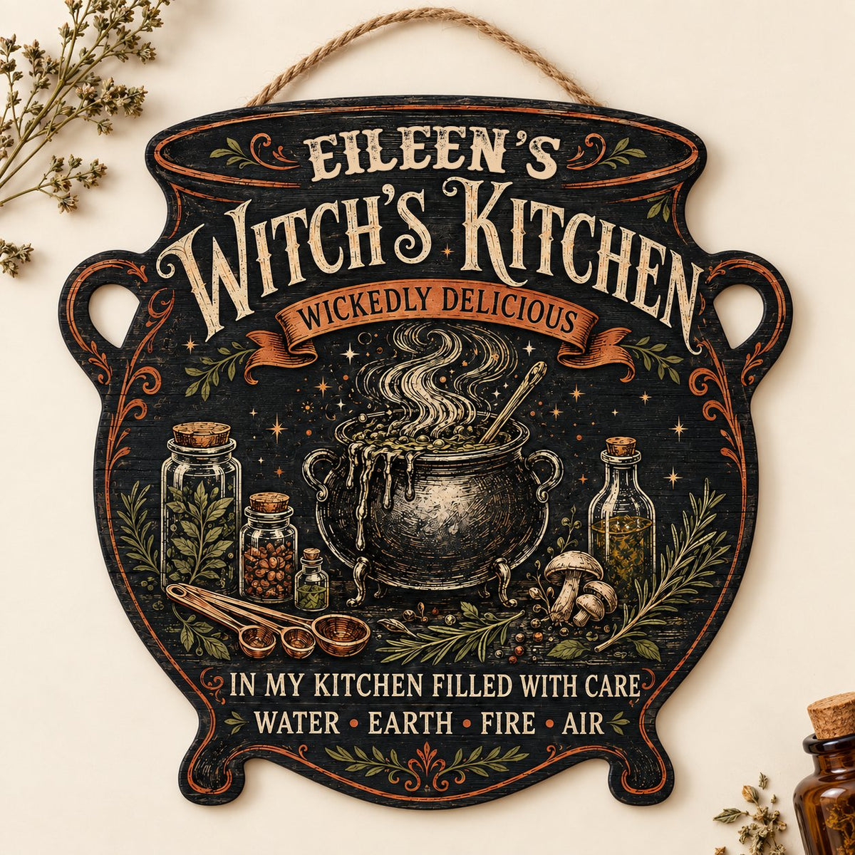 Custom-cut wooden sign shaped like a cauldron with herbs, potion jars, orange scroll and Witch's Kitchen text.