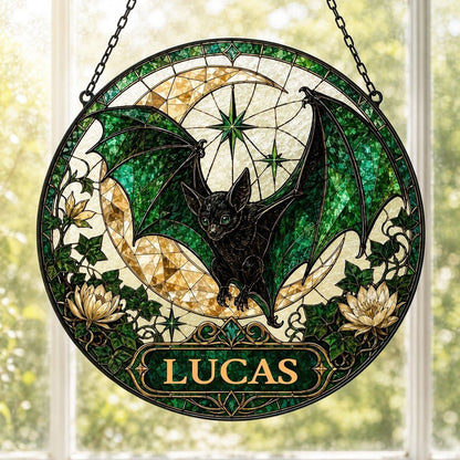 Round stained-glass style suncatcher with black bat, green wings, crescent moon, ivy, white flowers, and a personalized 
