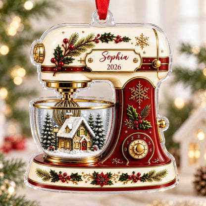 Stand mixer-shaped acrylic ornament with holly, gold snowflakes, and a snowy cottage scene in a glass bowl.
