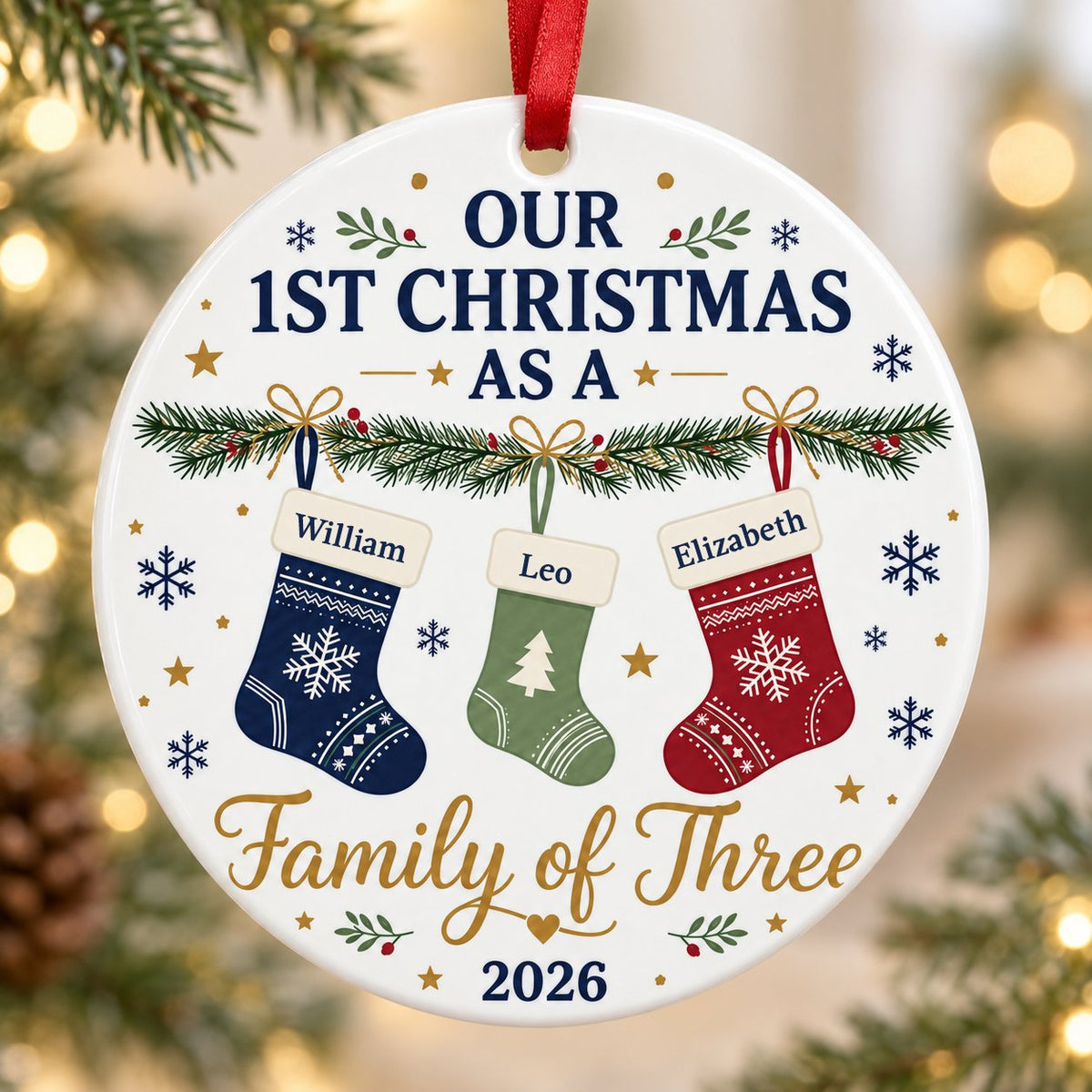 Round white ceramic ornament with garland, three stockings, and 'OUR 1ST CHRISTMAS AS A Family of Three 2026' text with 