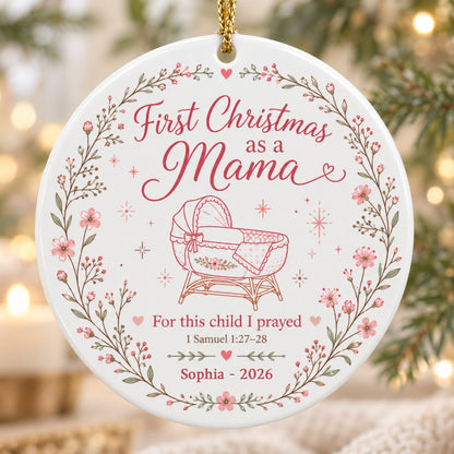 Round ceramic ornament with pink floral wreath, baby bassinet line art, stars, and First Christmas as a Mama.